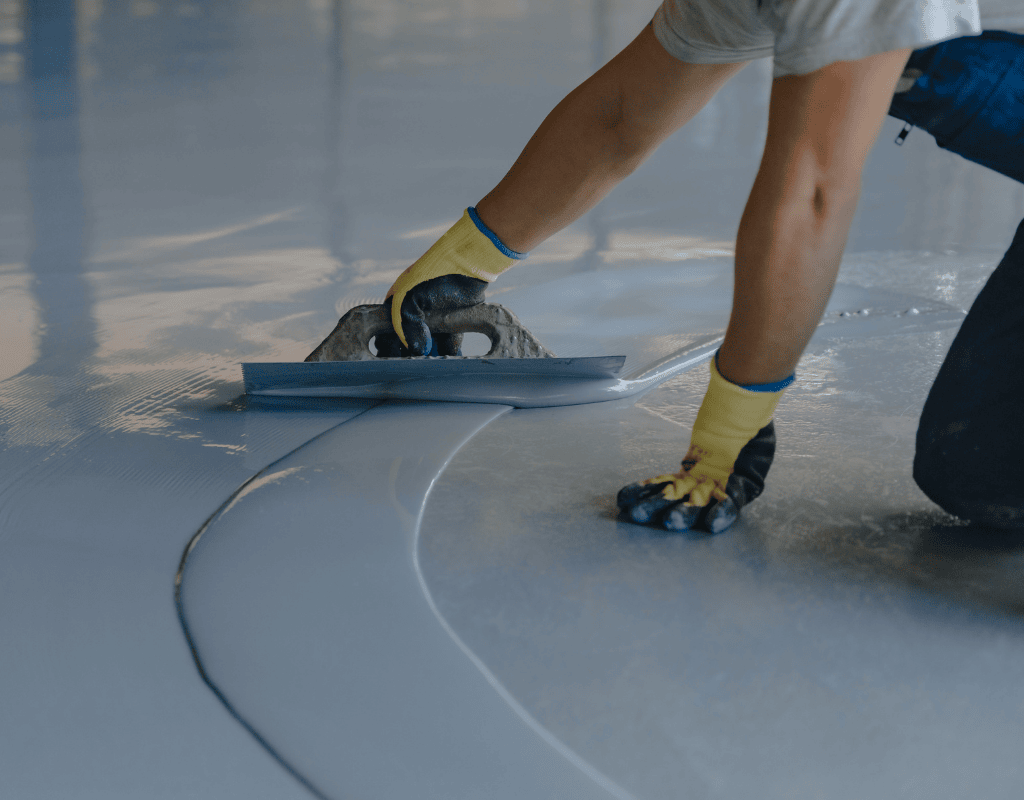 worker smoothing polyaspartic coating on concrete floor in Bergen County NJ